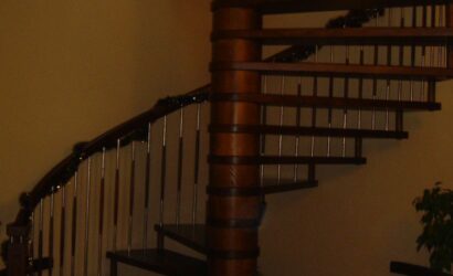 Drewniane schody kręte z metalowymi balustradami