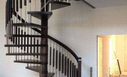 Drewniane schody kręte z metalowymi balustradami