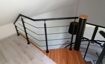 Drewniane schody kręte z metalowymi balustradami