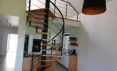 Drewniane schody kręte z metalowymi balustradami