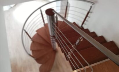Drewniane schody kręte z metalowymi balustradami