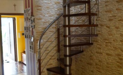 Drewniane schody kręte z metalowymi balustradami