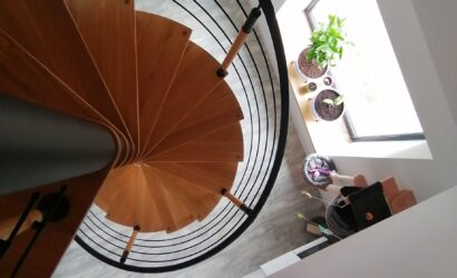 Drewniane schody kręte z metalowymi balustradami