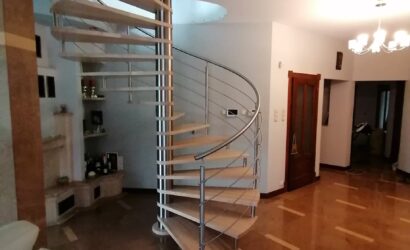 Drewniane schody kręte z metalowymi balustradami