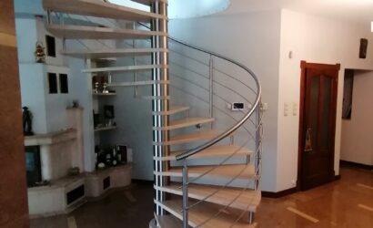 Drewniane schody kręte z metalowymi balustradami