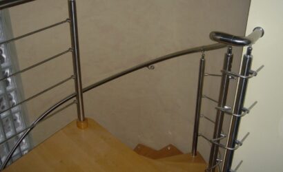 Drewniane schody kręte z metalowymi balustradami