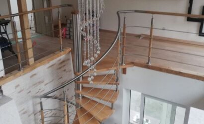 Drewniane schody kręte z metalowymi balustradami