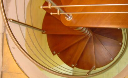 Drewniane schody kręte z metalowymi balustradami