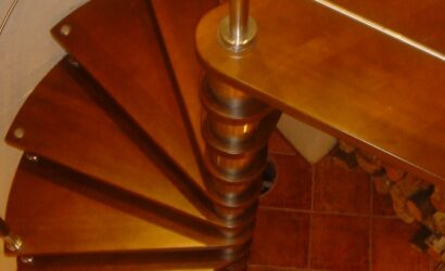 Drewniane schody kręte z metalowymi balustradami