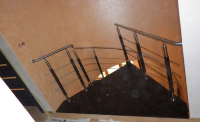 Drewniane schody kręte z metalowymi balustradami