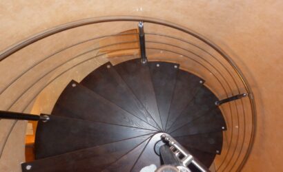 Drewniane schody kręte z metalowymi balustradami