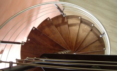 Drewniane schody kręte z metalowymi balustradami