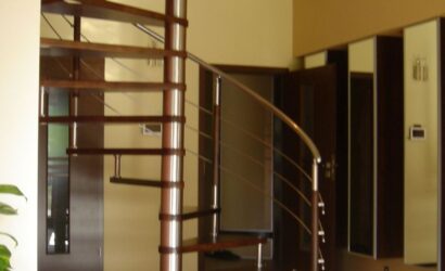 Drewniane schody kręte z metalowymi balustradami