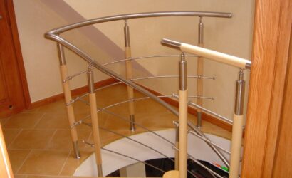 Drewniane schody kręte z metalowymi balustradami