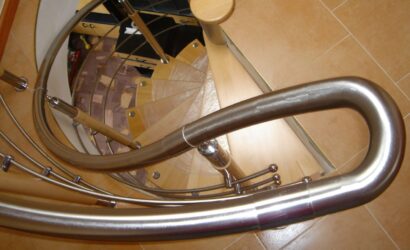 Drewniane schody kręte z metalowymi balustradami