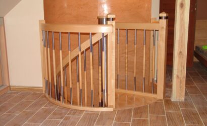 Drewniane schody kręte z metalowymi balustradami