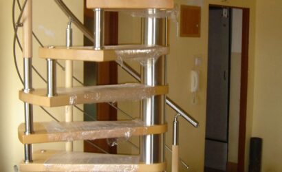 Drewniane schody kręte z metalowymi balustradami