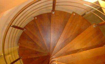 Drewniane schody kręte z metalowymi balustradami