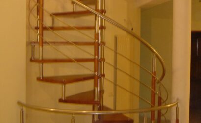 Drewniane schody kręte z metalowymi balustradami