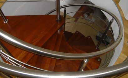 Drewniane schody kręte z metalowymi balustradami