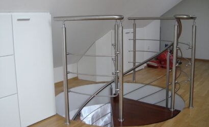 Drewniane schody kręte z metalowymi balustradami