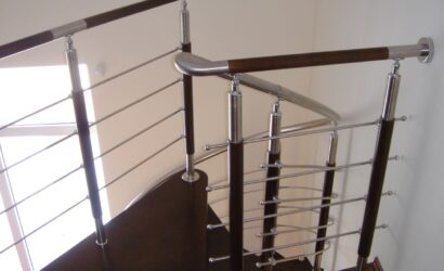 Drewniane schody kręte z metalowymi balustradami