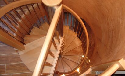 Drewniane schody kręte z metalowymi balustradami