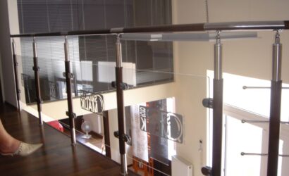 Drewniane schody kręte ze szklanymi balustradami