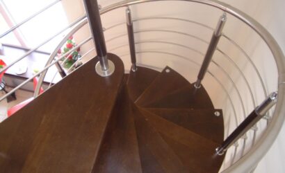 Drewniane schody kręte z metalowymi balustradami