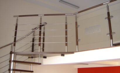 Drewniane schody kręte z metalowymi balustradami