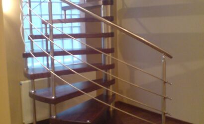 Drewniane schody kręte z metalowymi balustradami