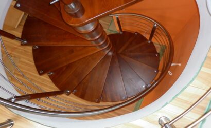 Drewniane schody kręte z metalowymi balustradami