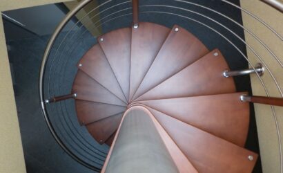 Drewniane schody kręte z metalowymi balustradami