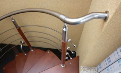 Drewniane schody kręte z metalowymi balustradami