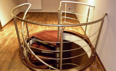 Drewniane schody kręte z metalowymi balustradami