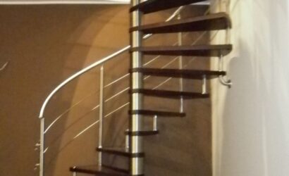 Drewniane schody kręte z metalowymi balustradami