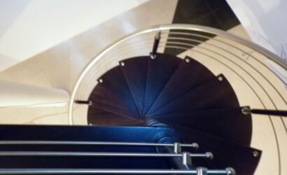 Drewniane schody kręte z metalowymi balustradami