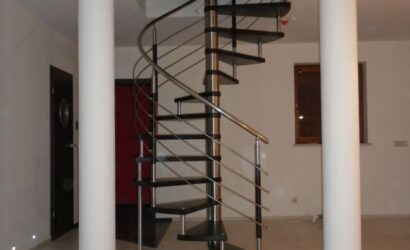 Drewniane schody kręte z metalowymi balustradami