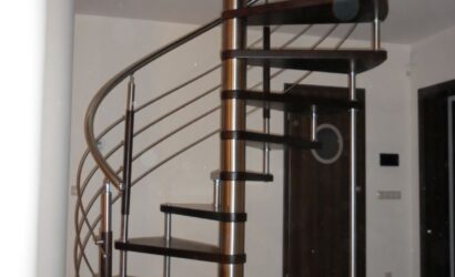 Drewniane schody kręte z metalowymi balustradami