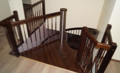 Drewniane schody kręte z metalowymi balustradami