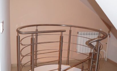 Drewniane schody kręte z metalowymi balustradami