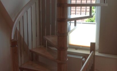 Drewniane schody kręte z metalowymi balustradami