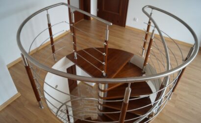 Drewniane schody kręte z metalowymi balustradami