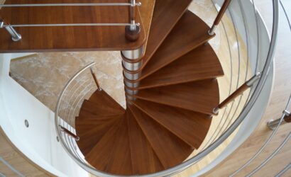 Drewniane schody kręte z metalowymi balustradami