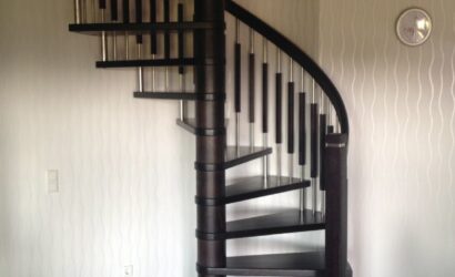Drewniane schody kręte z metalowymi balustradami