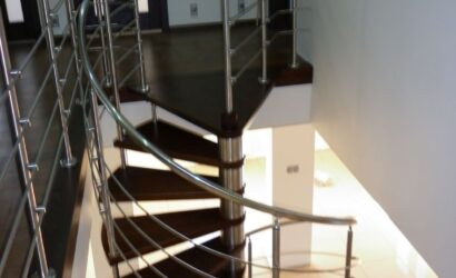 Drewniane schody kręte z metalowymi balustradami