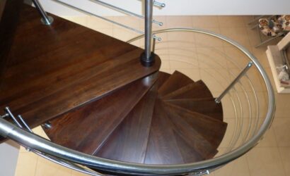 Drewniane schody kręte z metalowymi balustradami