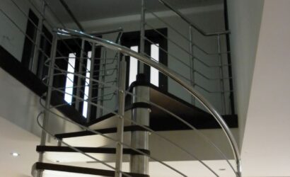 Drewniane schody kręte z metalowymi balustradami