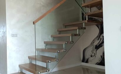 Drewniane schody wewnętrzne ze szklanymi balustradami