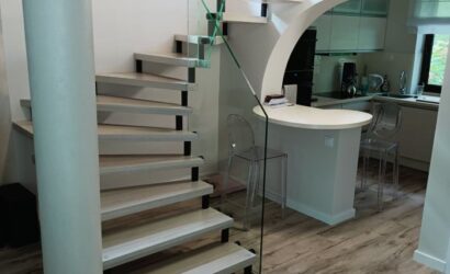 Drewniane schody wewnętrzne ze szklanymi balustradami